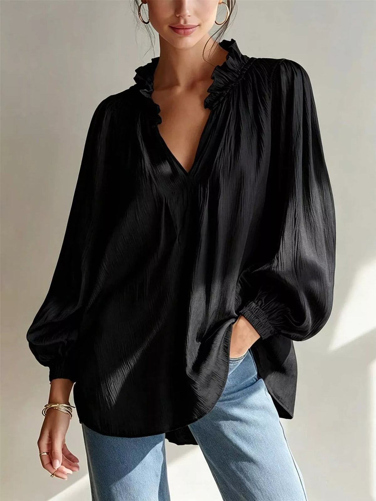 Black long-sleeve blouse with ruffle-trim V-neck and gathered cuff