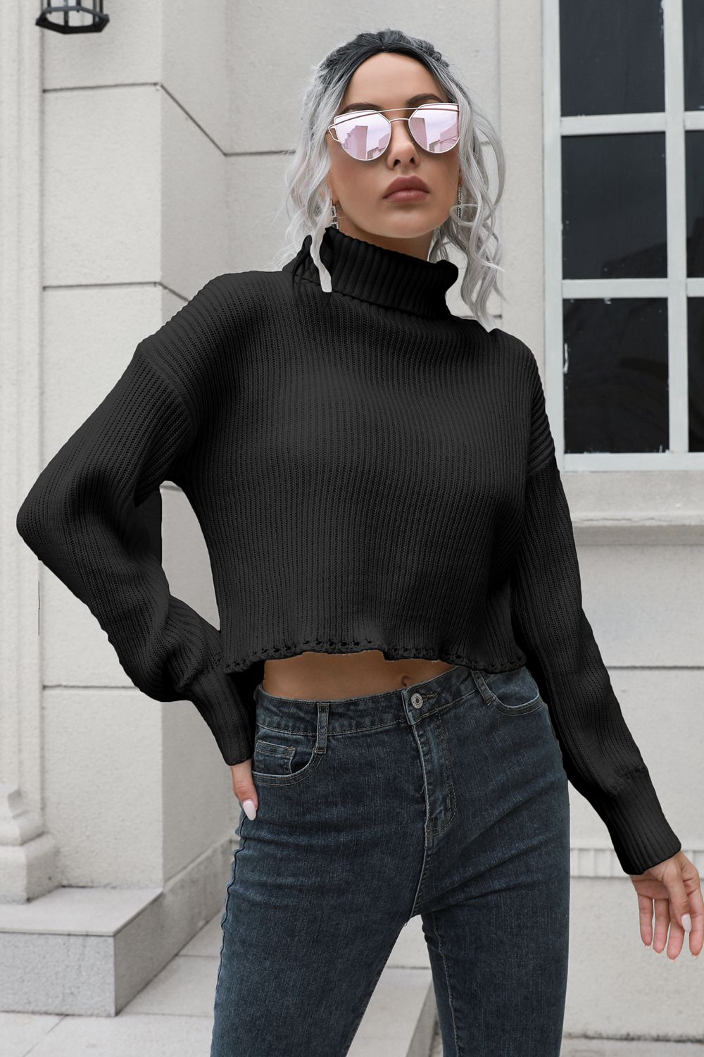 Black turtleneck dropped-shoulder sweater, long ribbed sleeves, cropped hem.