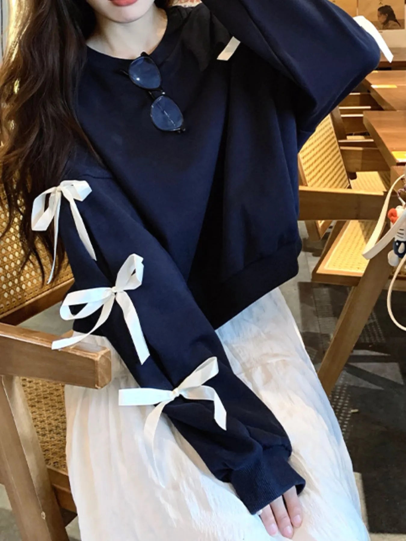Dark blue sweatshirt with white ribbon bows on sleeve cuffs