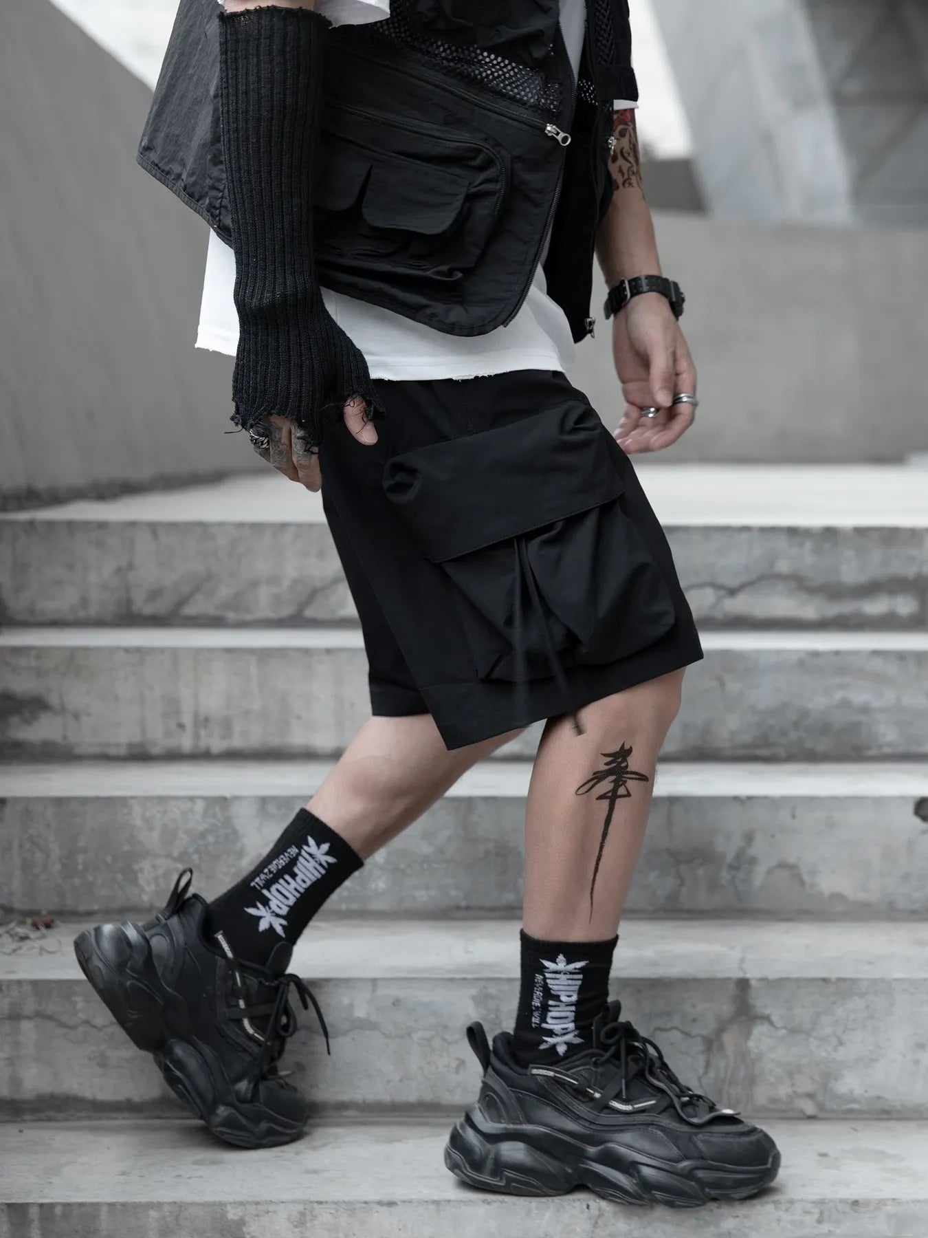 Black cargo shorts with oversized side flap pockets and wide leg openings