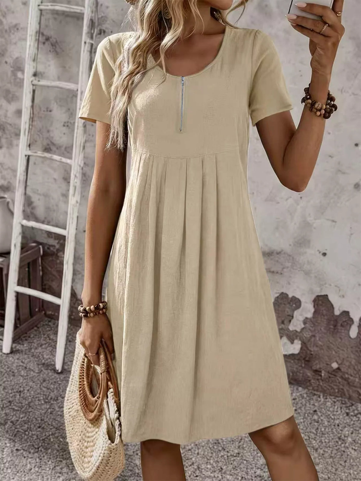 Beige short-sleeve pleated dress with front zipper and scoop neckline