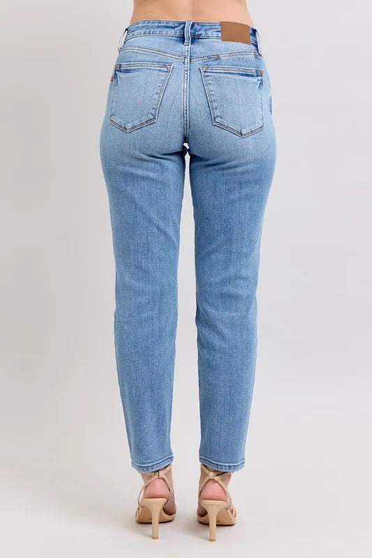 Light blue mid-rise slim jeans from the back with two rear pockets and cropped ankle hem