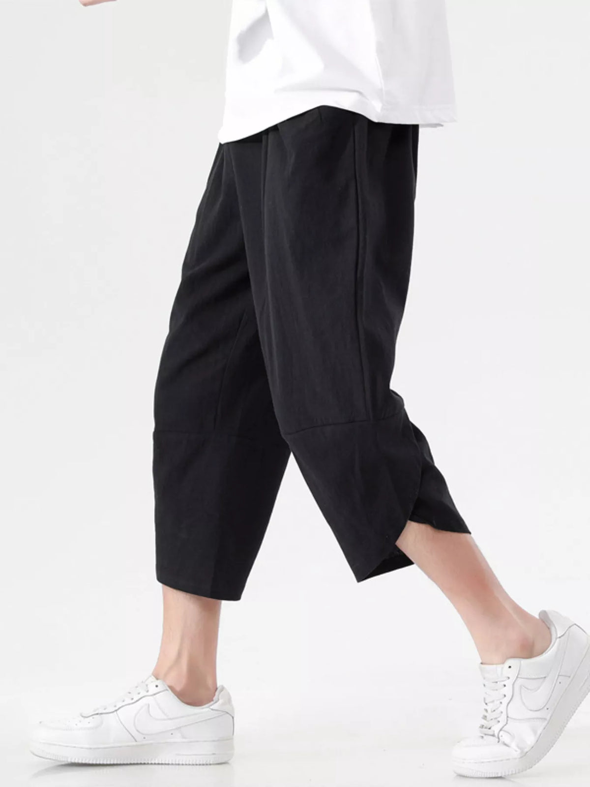 Black loose-fit cropped harem pants with drop-crotch drape and wide cuffs