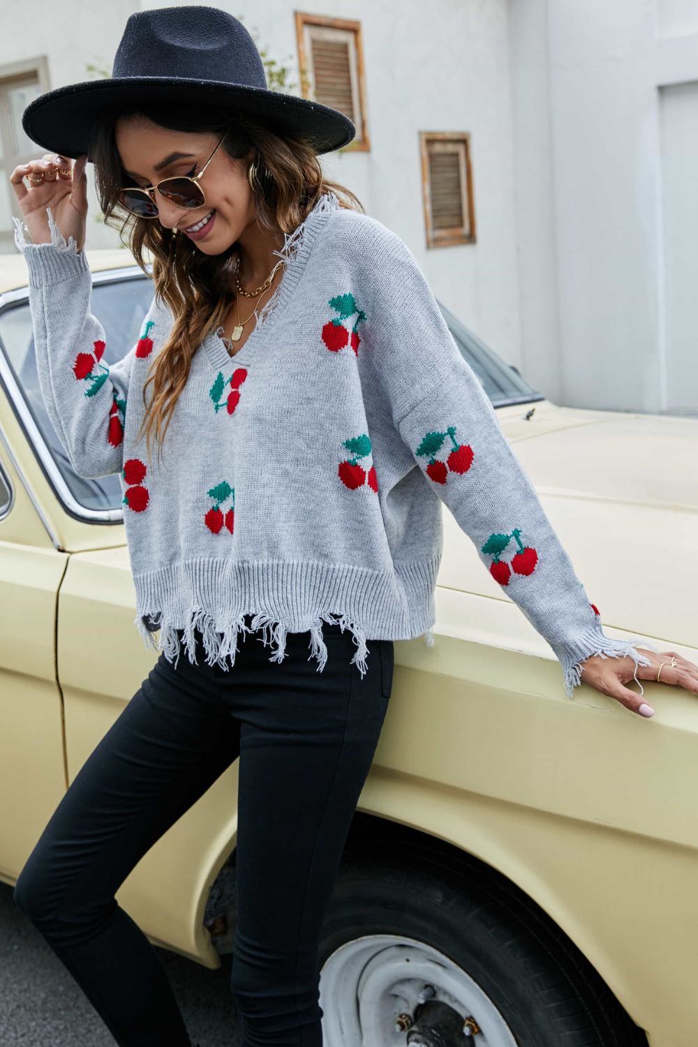 Sky blue V-neck cherry print sweater with frayed fringe hem and cuffs