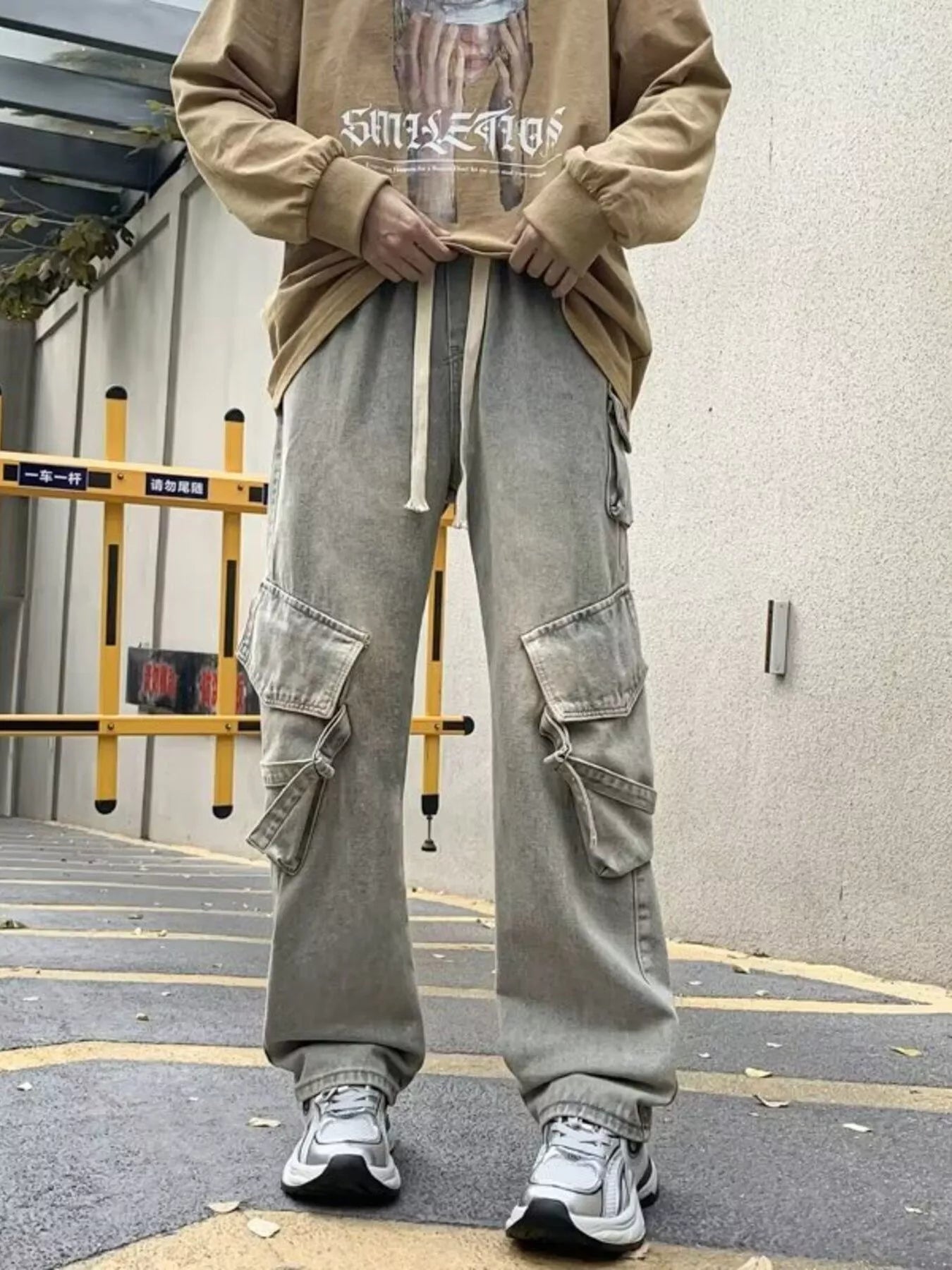 Light gray wide-leg cargo jeans with drawstring waist and multiple side flap pockets