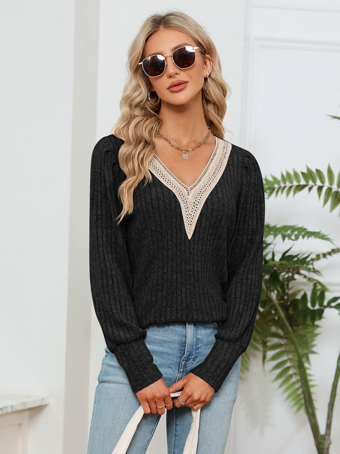 Black ribbed knit V-neck blouse with lace trim and long sleeves