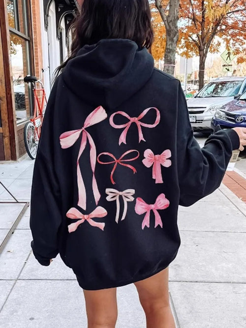 Black long-sleeve hoodie with large pink bow graphic on the back