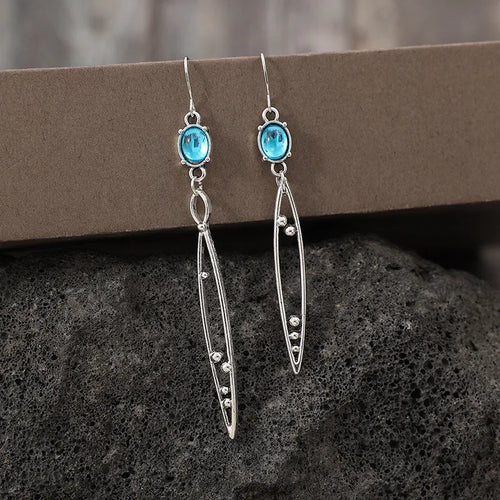 Silver-tone drop earrings with turquoise oval stones and slim oval dangles studded