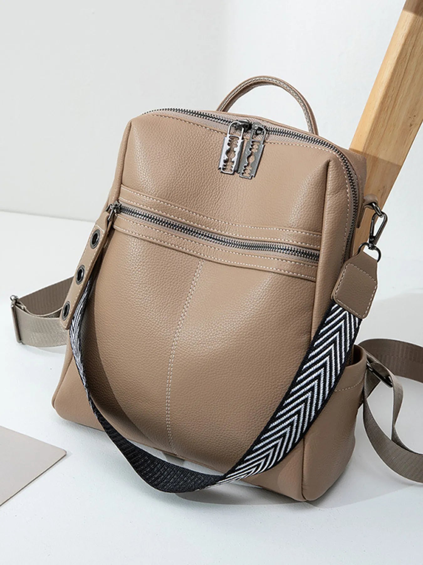 Khaki leather backpack bag with front zip pocket, top handle, adjustable strap