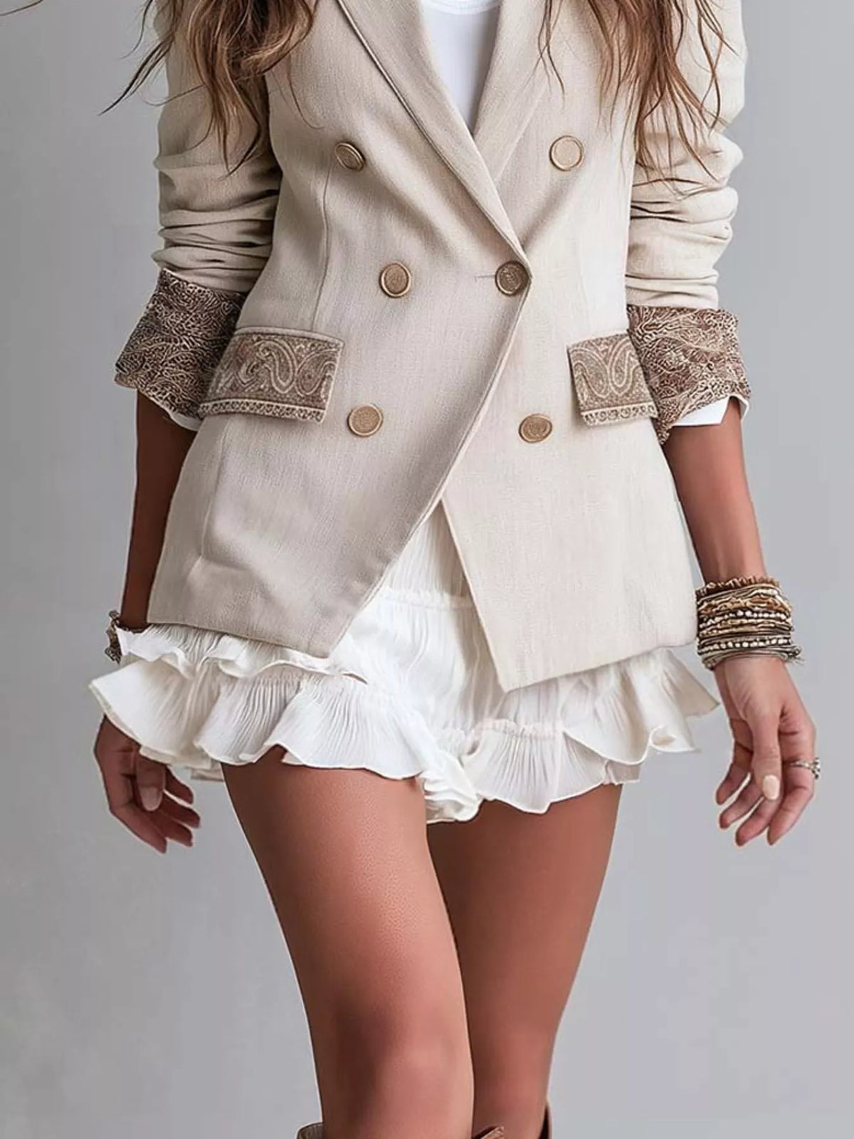 Cream double-breasted blazer with lapel, gold buttons, lace cuffs, layered ruffle hem