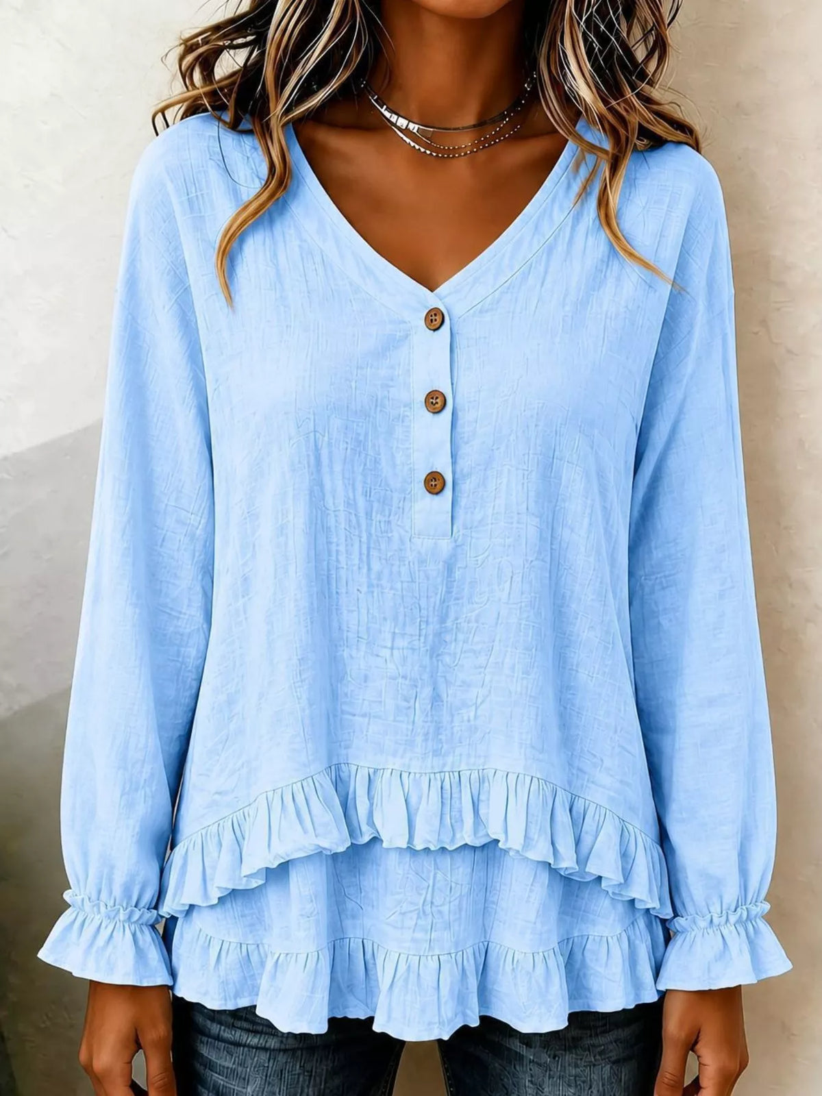 Light blue V-neck blouse with long sleeves, button front, and layered ruffle bottom