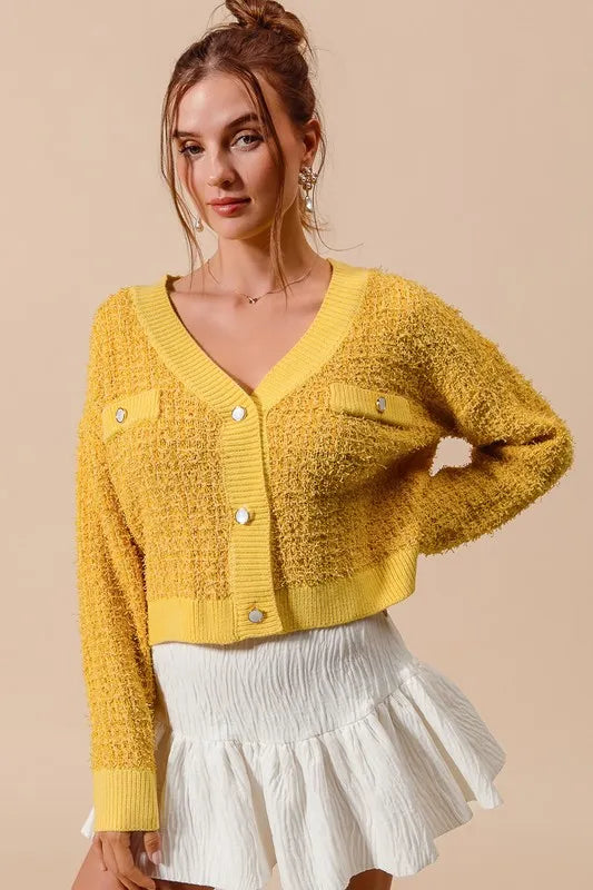 Mustard yellow knit cardigan with V-neck, button front, and patch pockets
