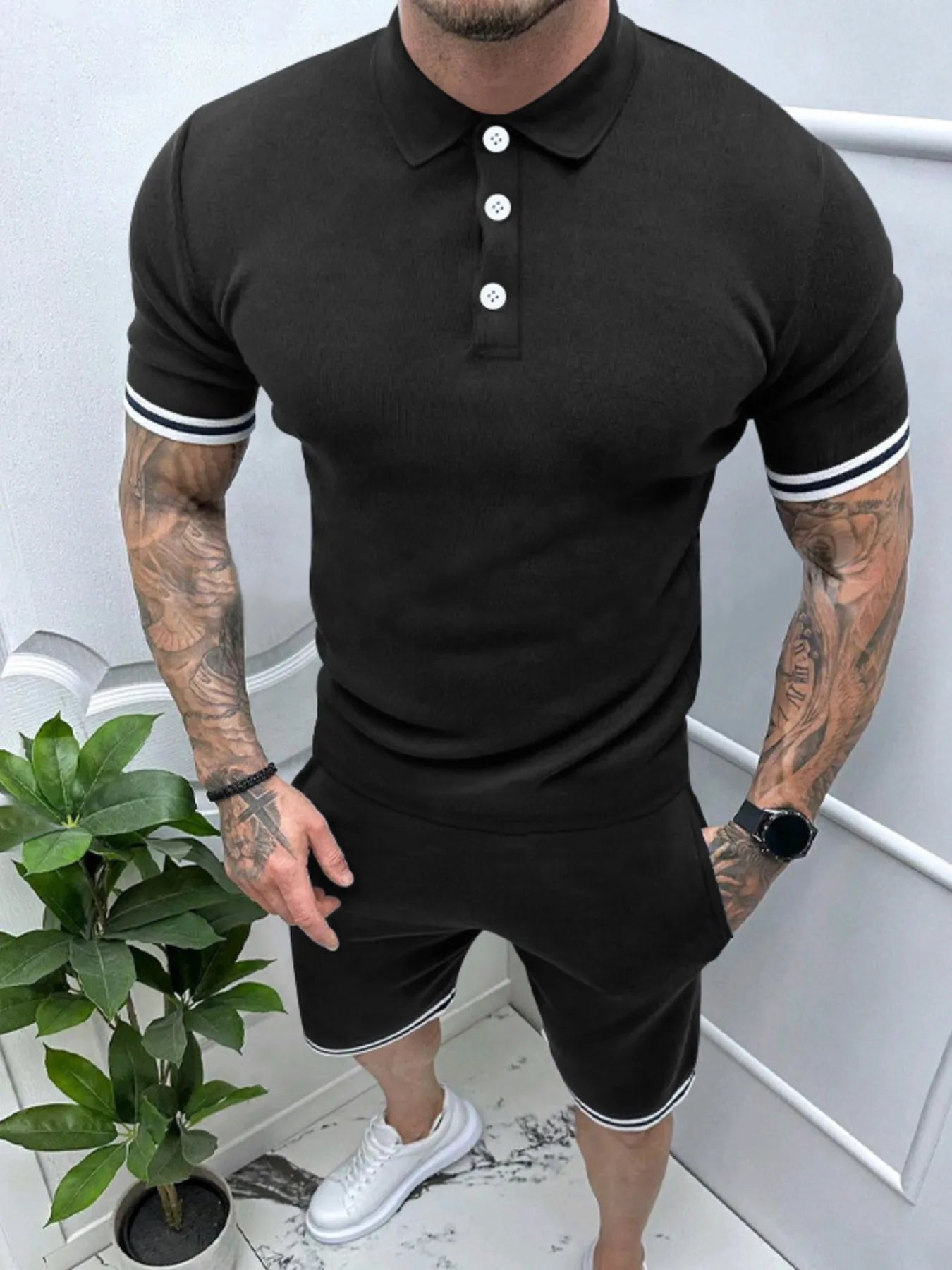 Men's black polo and shorts set with striped sleeve cuffs and button placket.