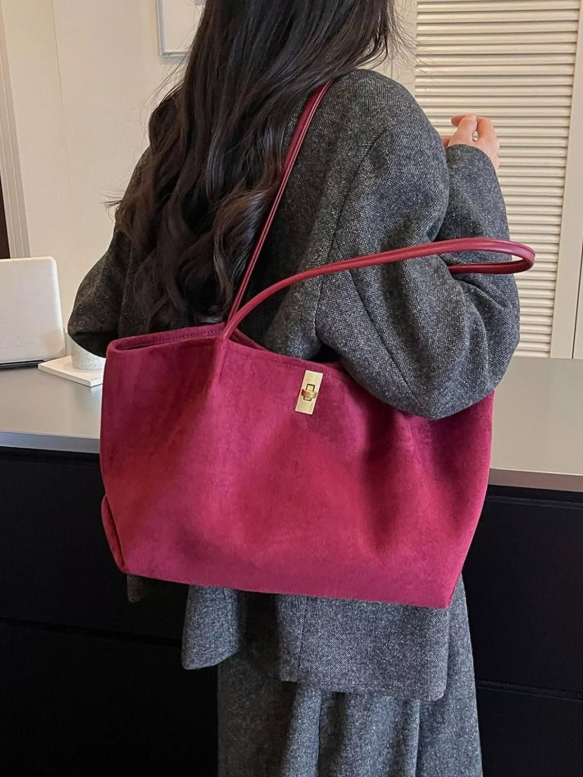 Burgundy suede tote bag with red top handles and gold turn-lock clasp, side view