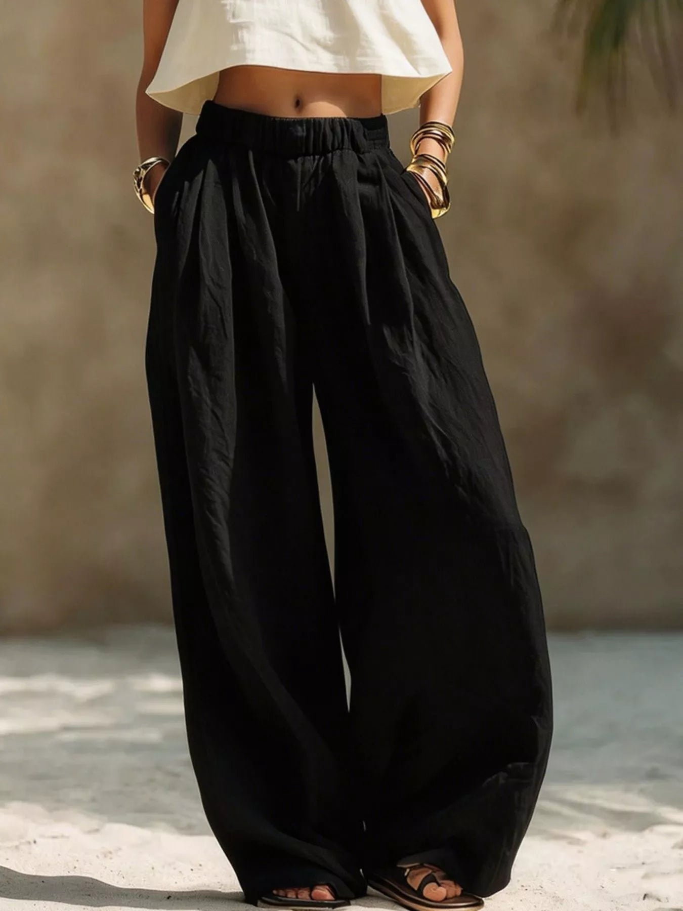 Black wide-leg pants with elastic waist and gathered pleats, full-length fit