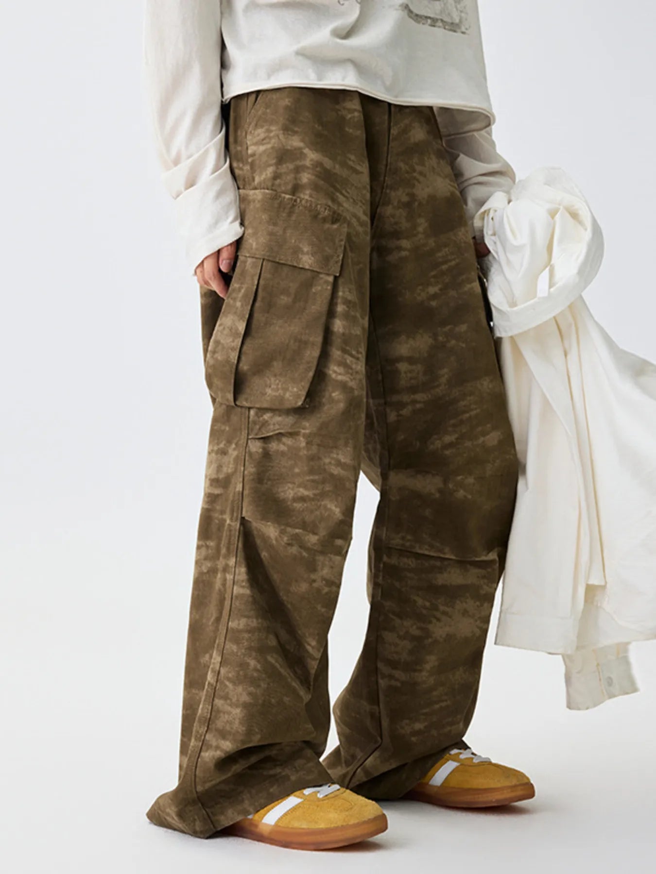 Tan camouflage cargo pants with two side cargo pockets and wide legs