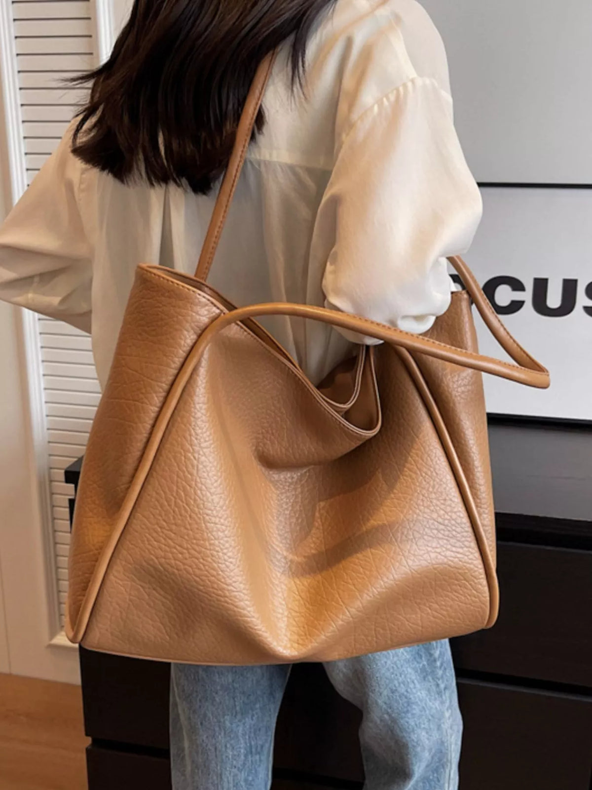 Khaki vegan leather tote bag with long handles and curved front pocket opening