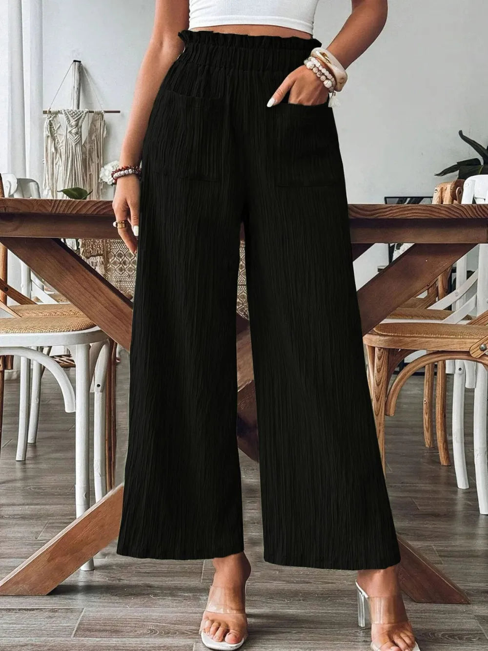 Black wide-leg pants with elastic waistband and front patch pockets, textured fabric