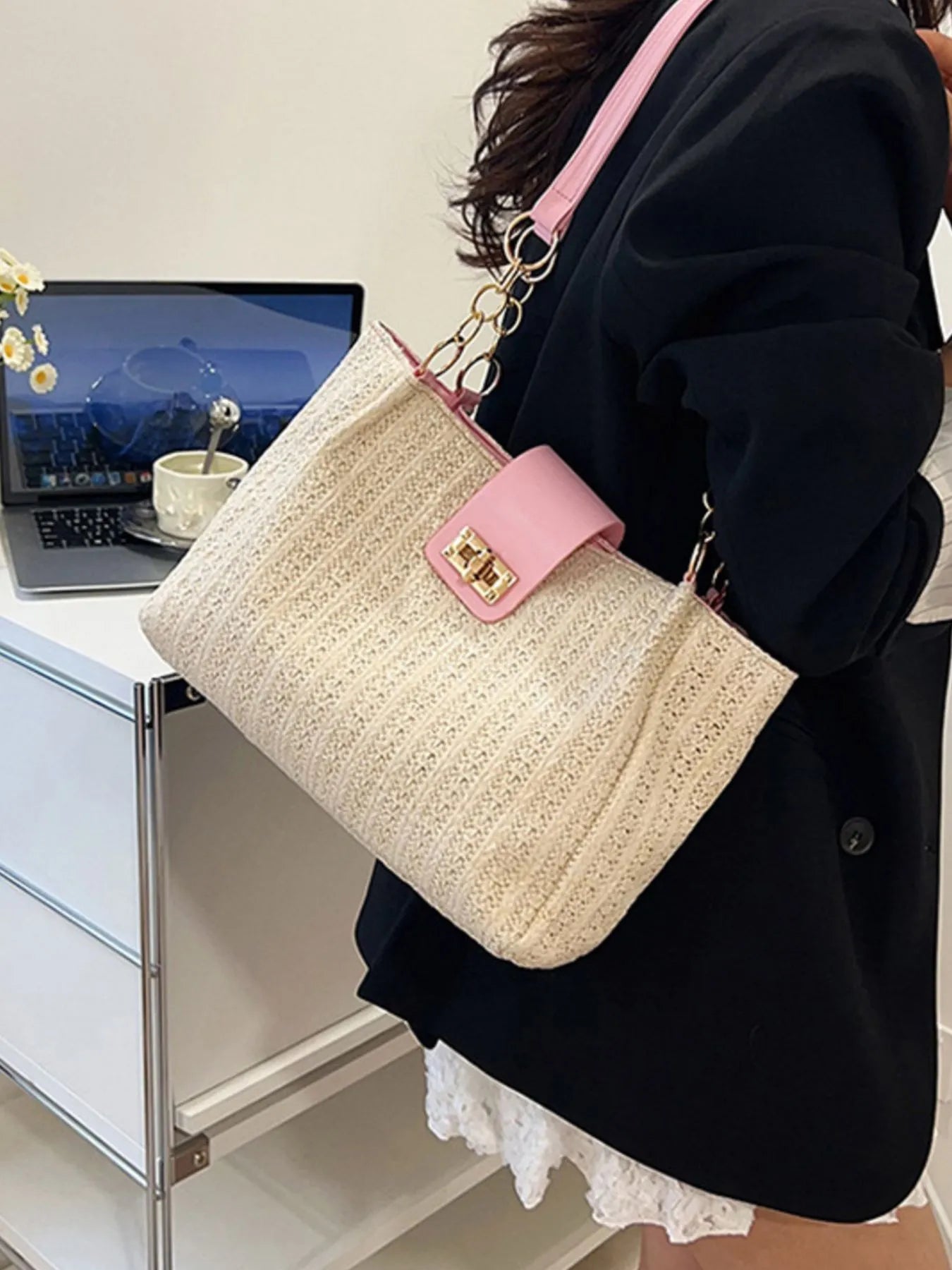 Woven straw shoulder bag with pink leather strap handles and gold-tone chain, beige texture
