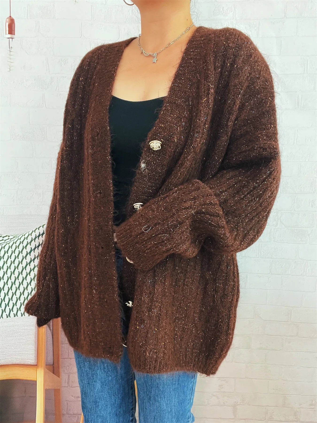 Brown cable-knit cardigan with V-neck and button front, shown with sleeve detail