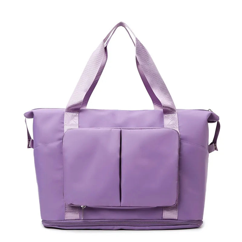 Lilac travel duffel bag with front organizer pocket, top handles, and side carry straps.
