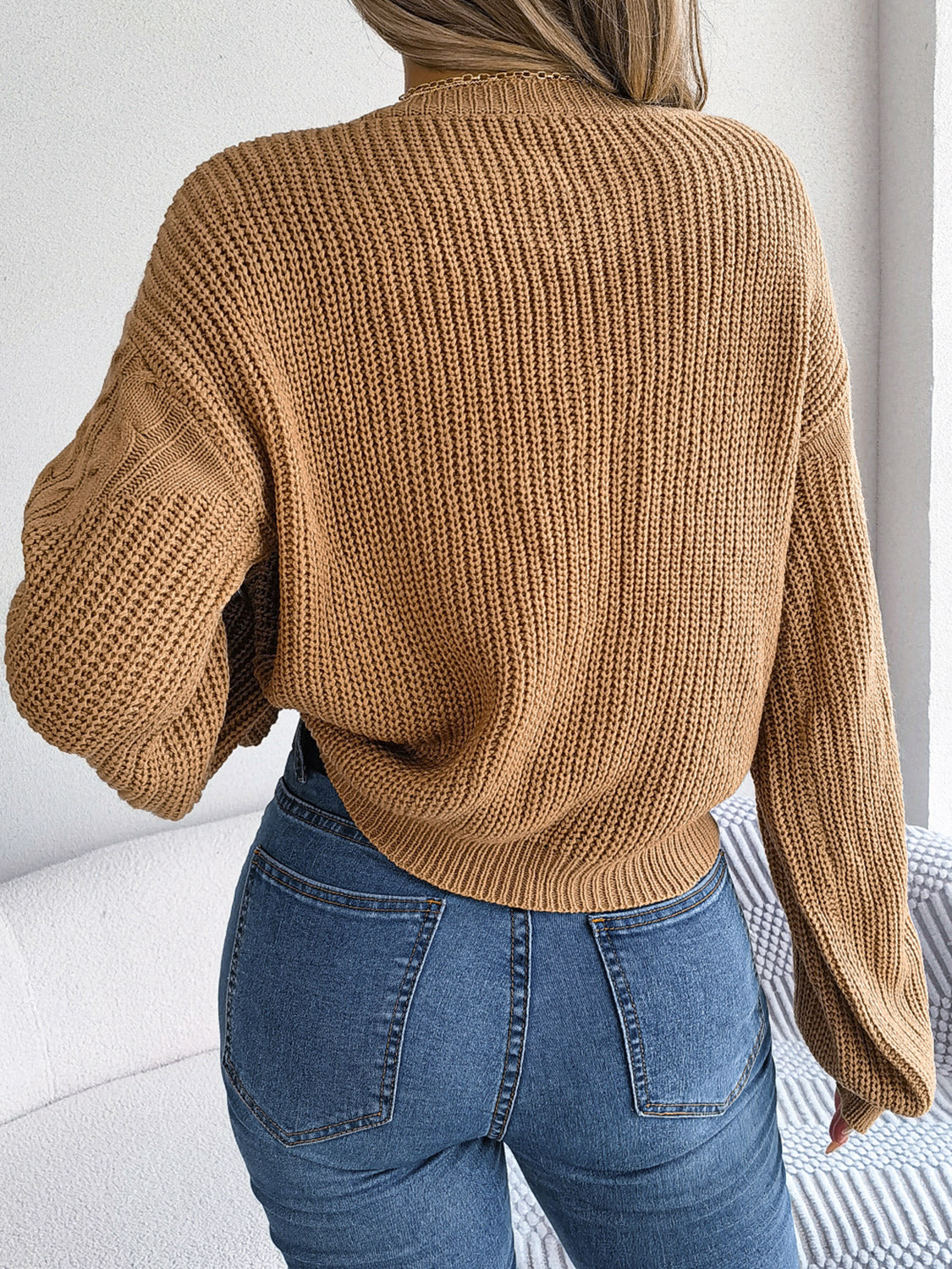 Taupe cable-knit sweater back view, drop shoulder knit with cable pattern