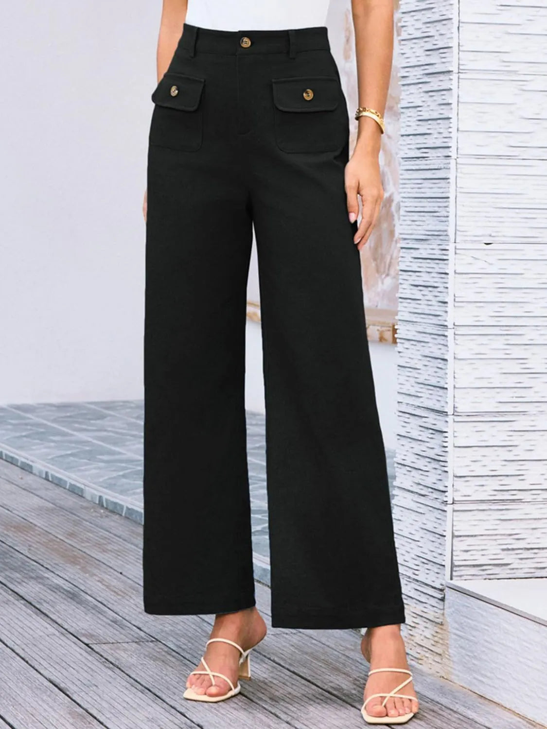 High-waist wide-leg pants, black; front flap pockets with gold buttons, wide-leg silhouette.
