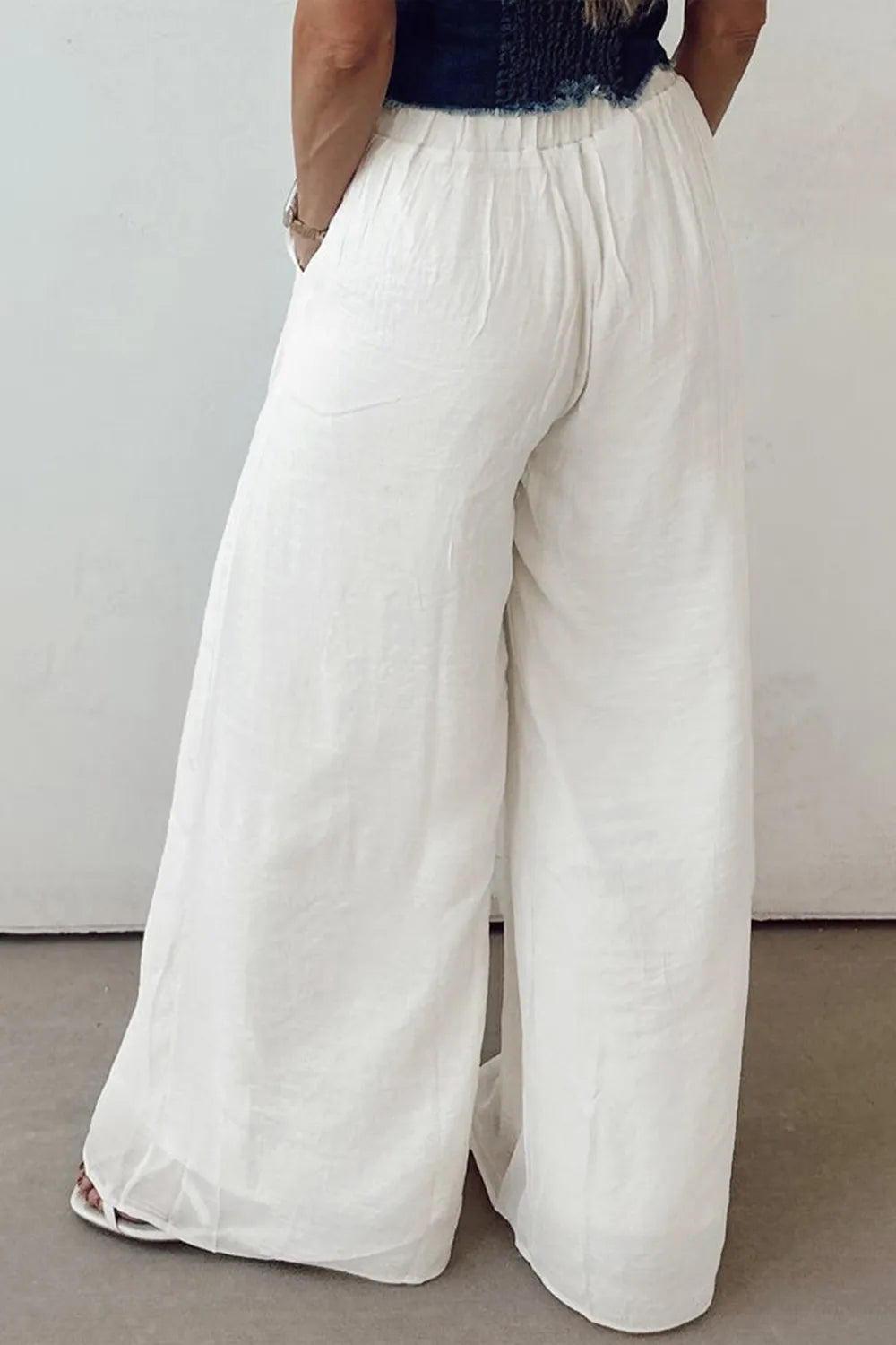 White wide-leg pants with drawstring waistband and loose straight drape