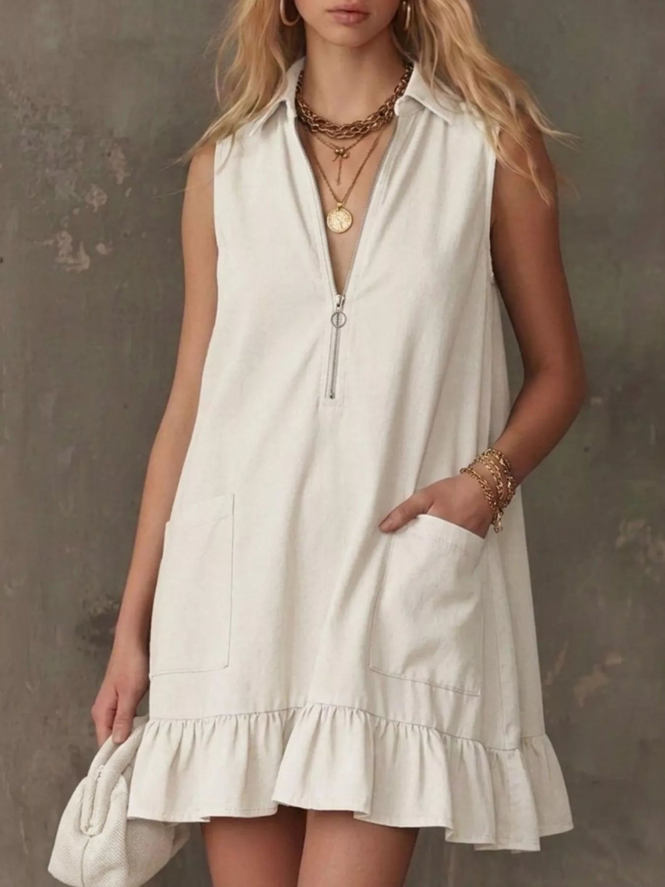 White sleeveless collared zip-front ruffle hem dress with front zip and pockets