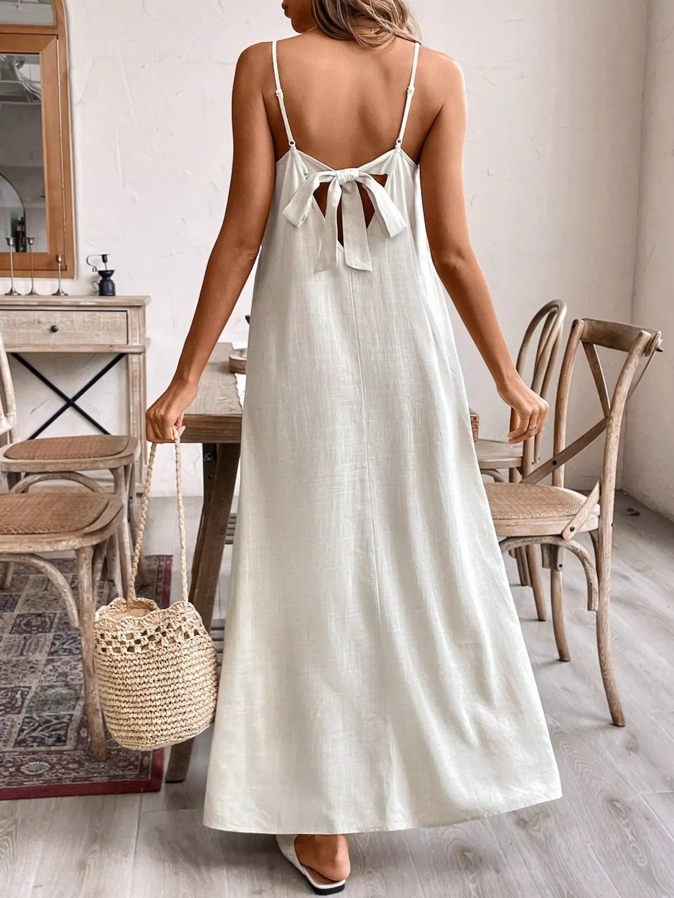 Back of cream spaghetti strap maxi dress with tied bow at upper back