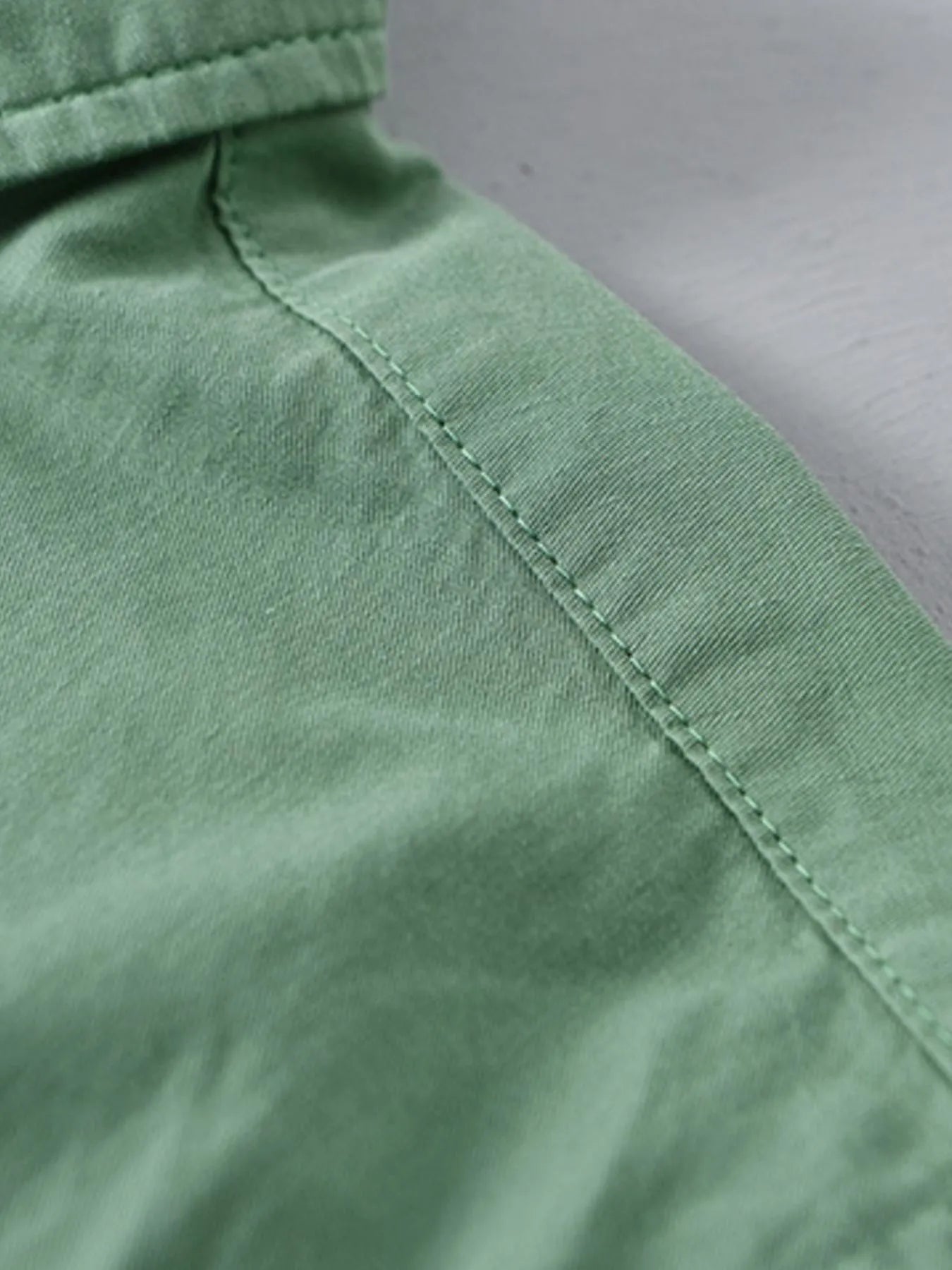 Green short-sleeve button-up shirt shoulder seam and neckline