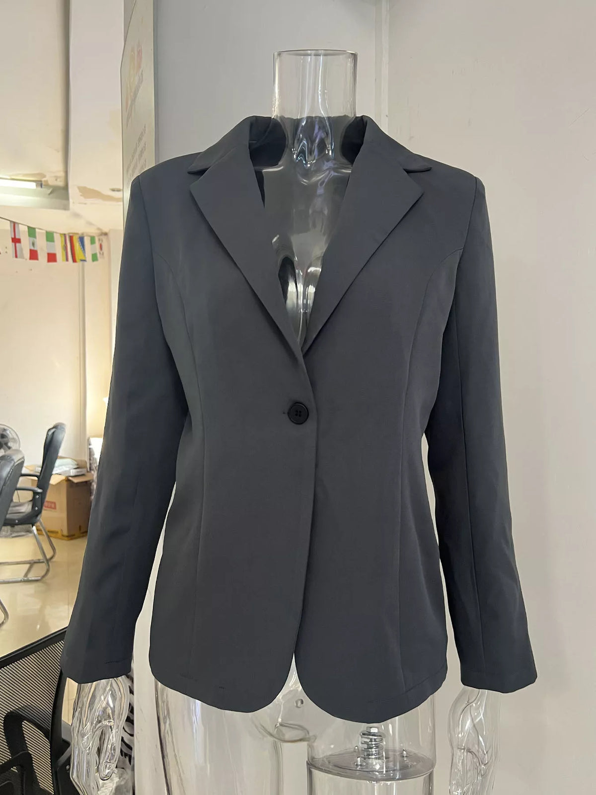 Dark gray single-button blazer on mannequin, notched lapels and front pockets.