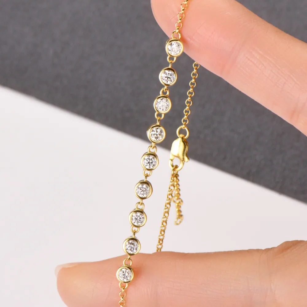 Gold-tone bracelet with round blue stones and dangling charm chain