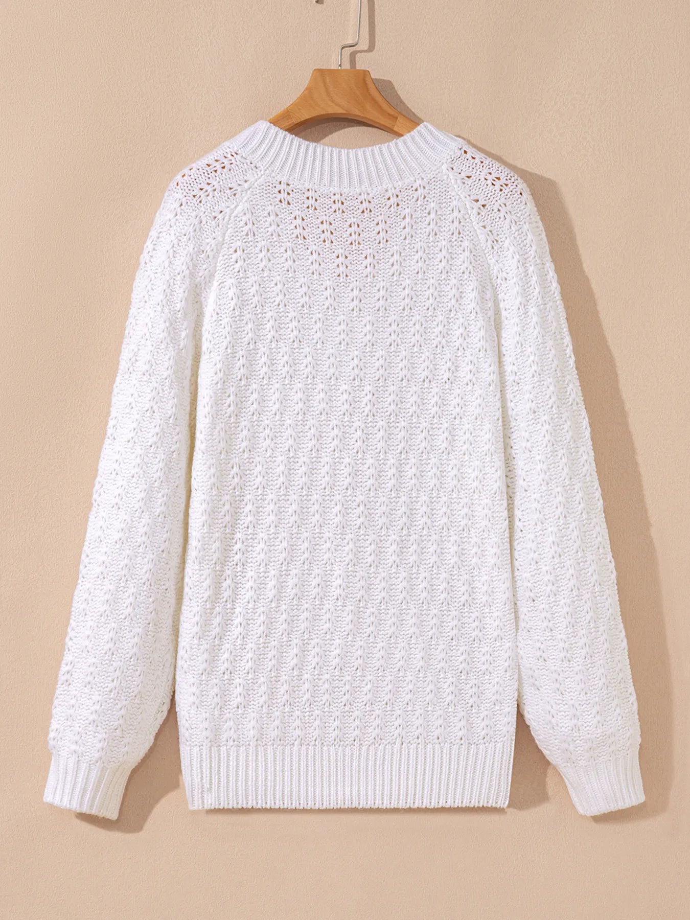 White textured knit crew-back sweater on hanger with long sleeves and ribbed hem.
