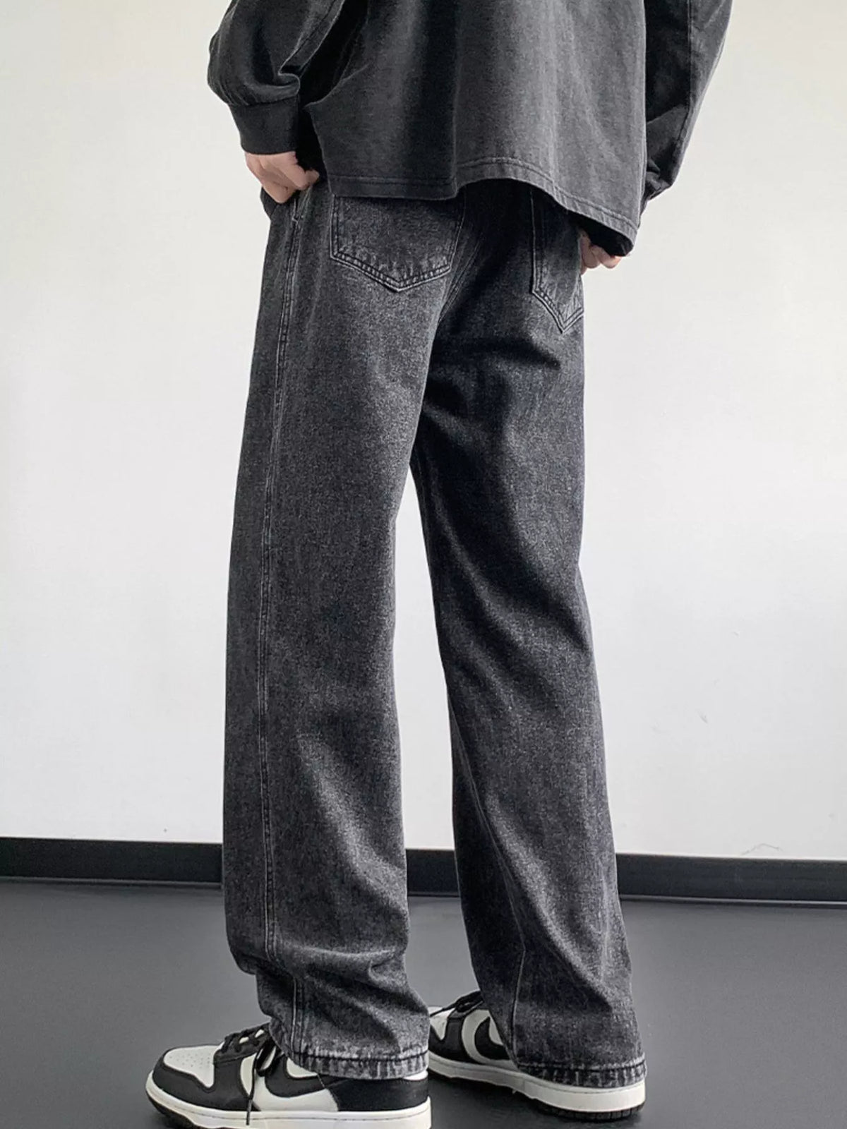 Dark gray washed denim jeans with loose fit, wide legs, and side pockets