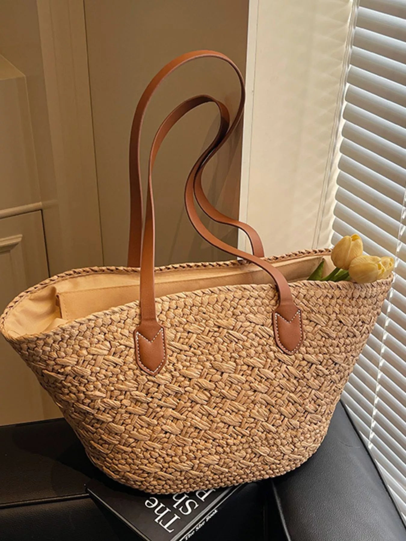 Caramel woven tote bag with brown leather handles, open top, and interior lining