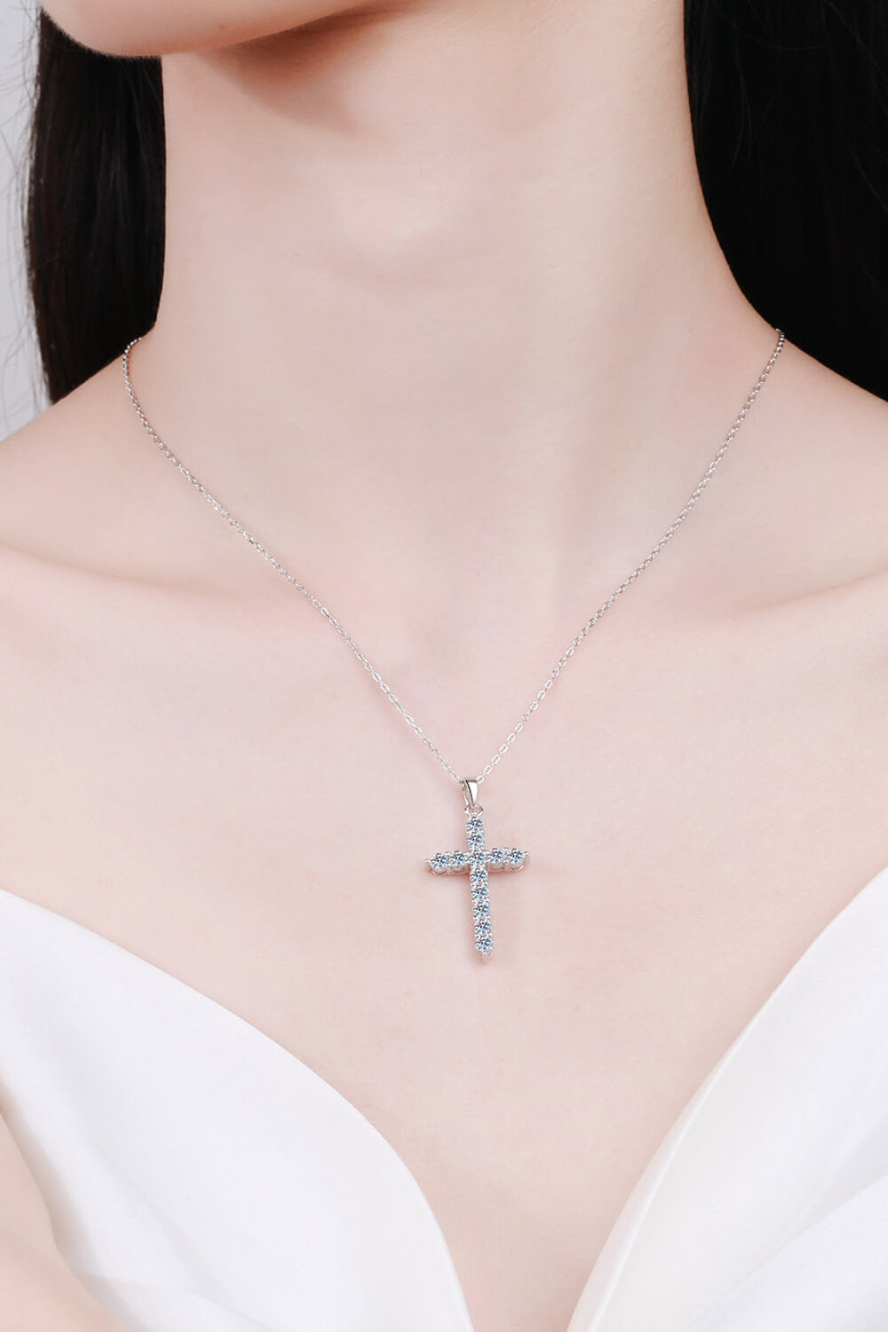 Sterling silver cross moissanite necklace on collarbone, cross pendant