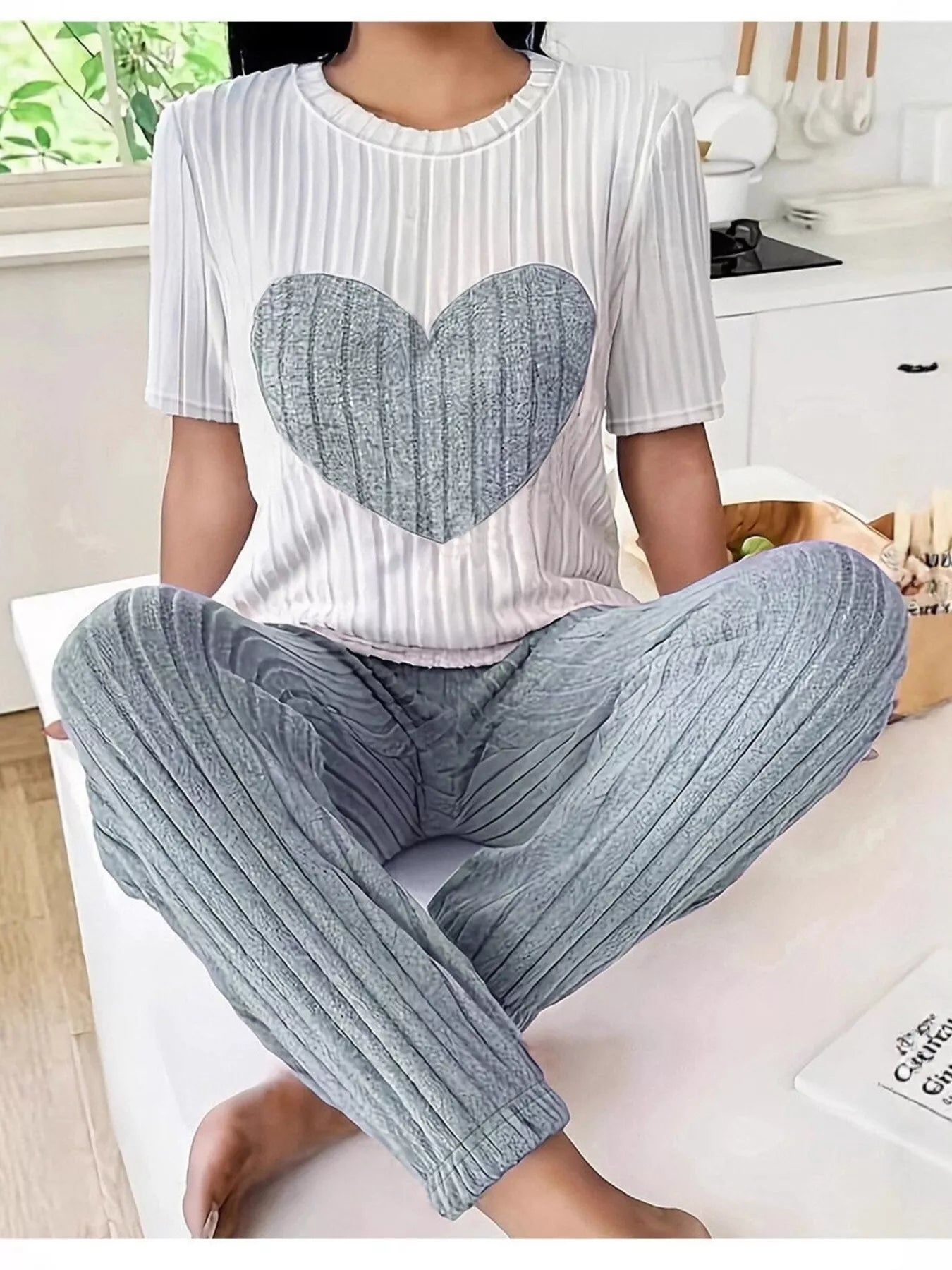 Heart ribbed knit lounge set with white striped top and light gray pants, seated view