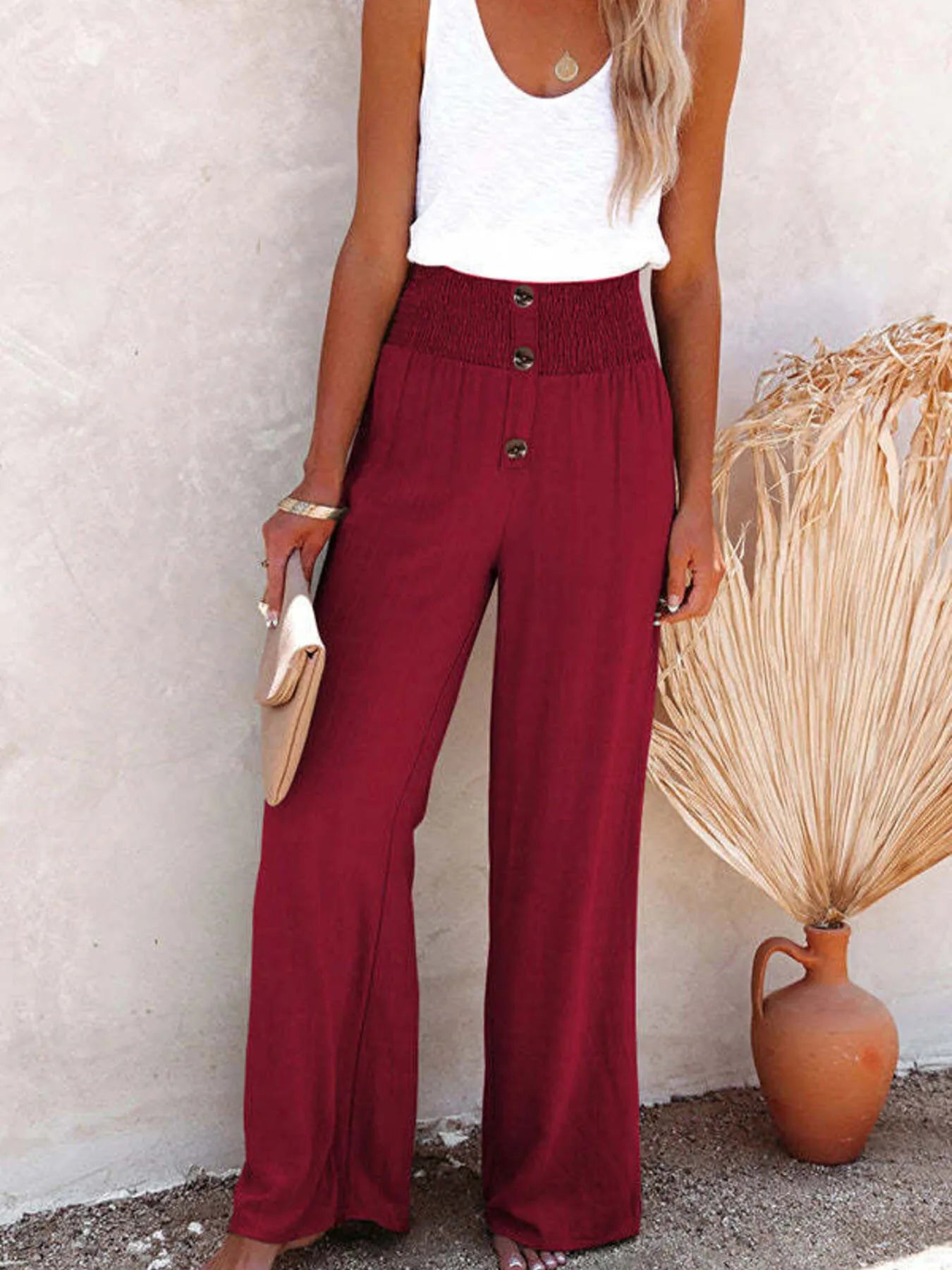 Burgundy high-waisted wide-leg pants with textured fabric and front button placket