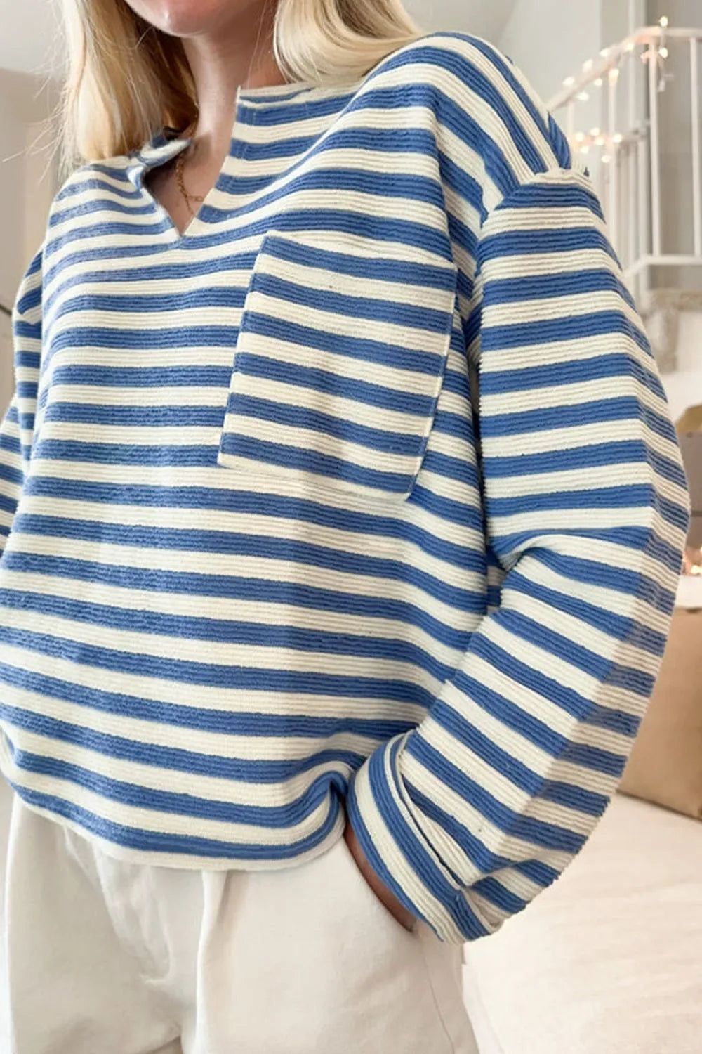 Blue and white striped long-sleeve top with chest pocket and button placket