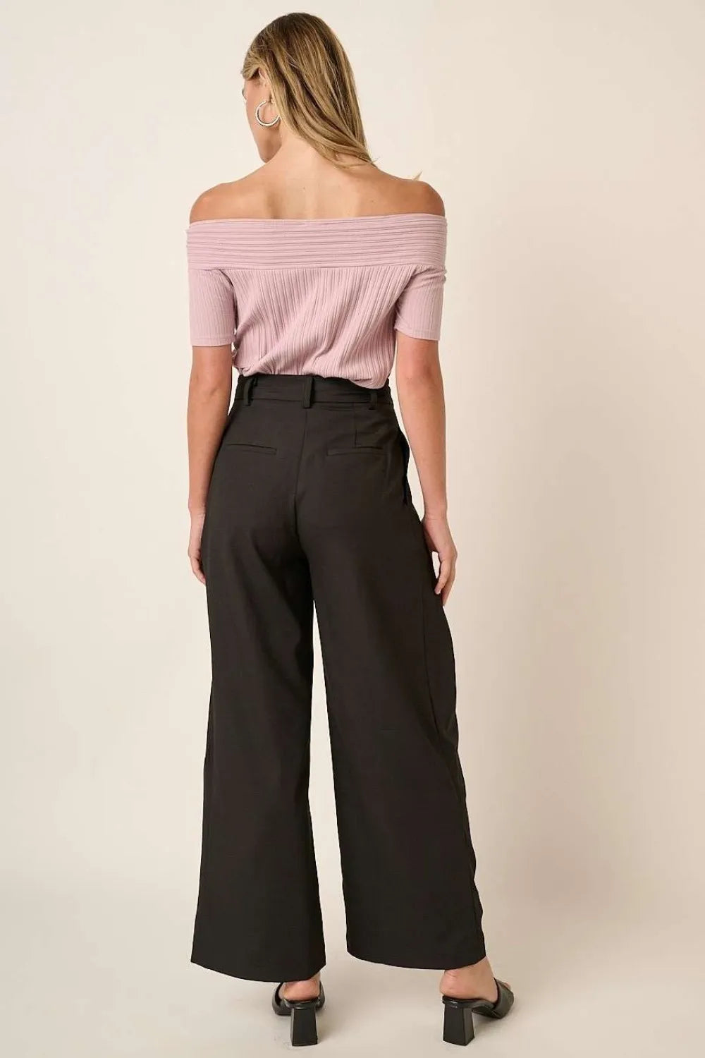 Black high-waisted wide-leg pants with deep pleats and back waistband detail