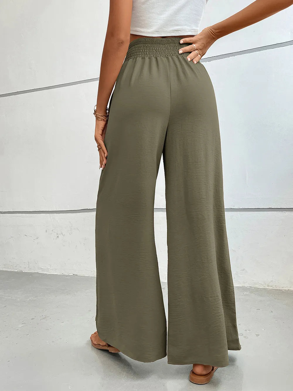 Wide-leg pants in muted olive with elastic waist and flowing wide legs