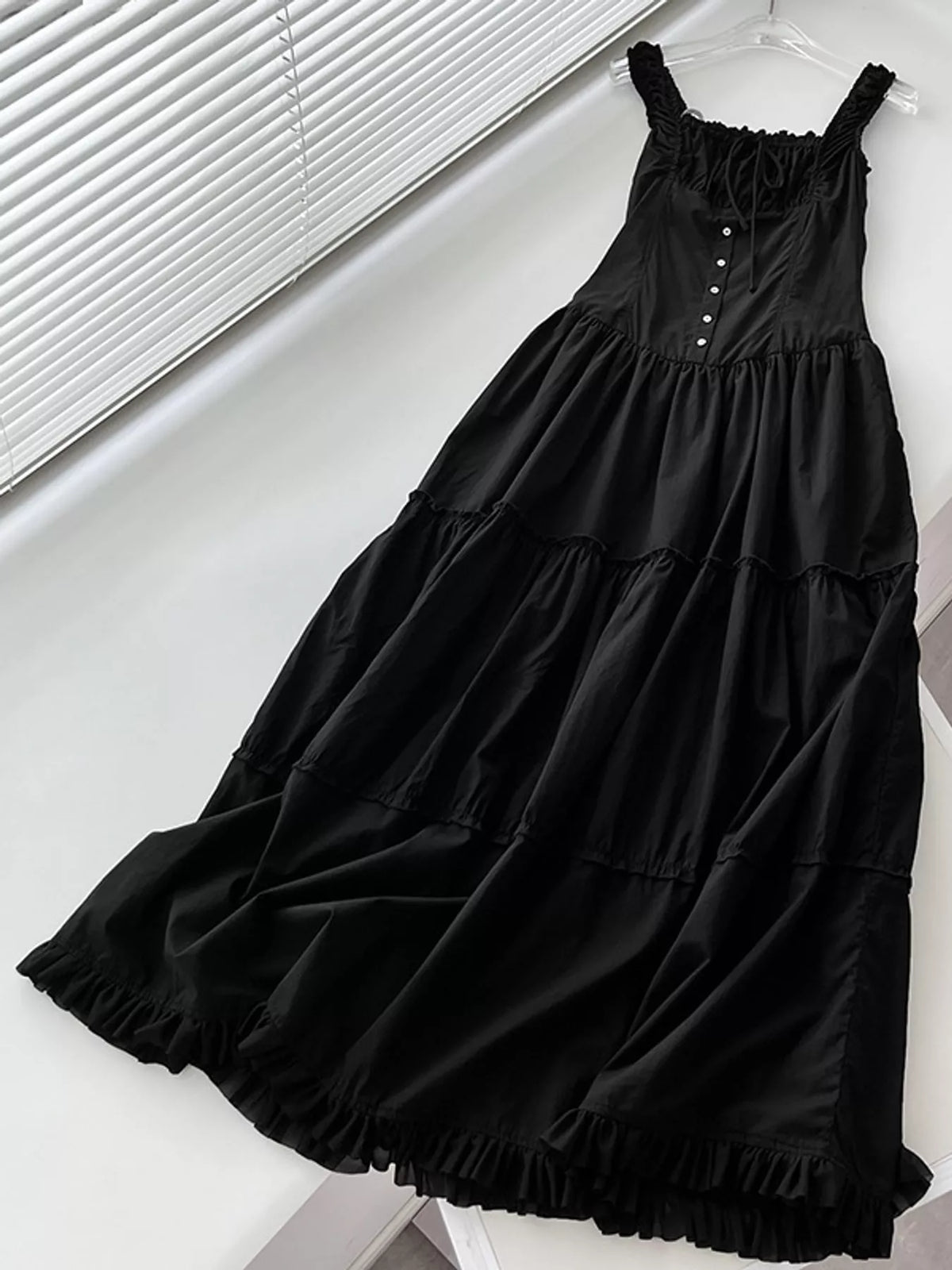 Black tiered maxi dress flat lay with square neckline, button front, and ruffled hem