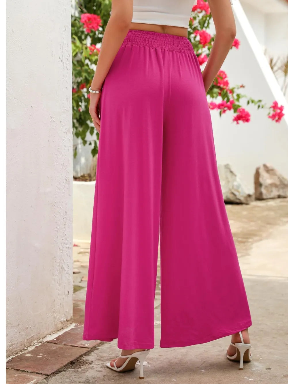 Hot pink wide-leg pants with elastic waist and side pockets, back view
