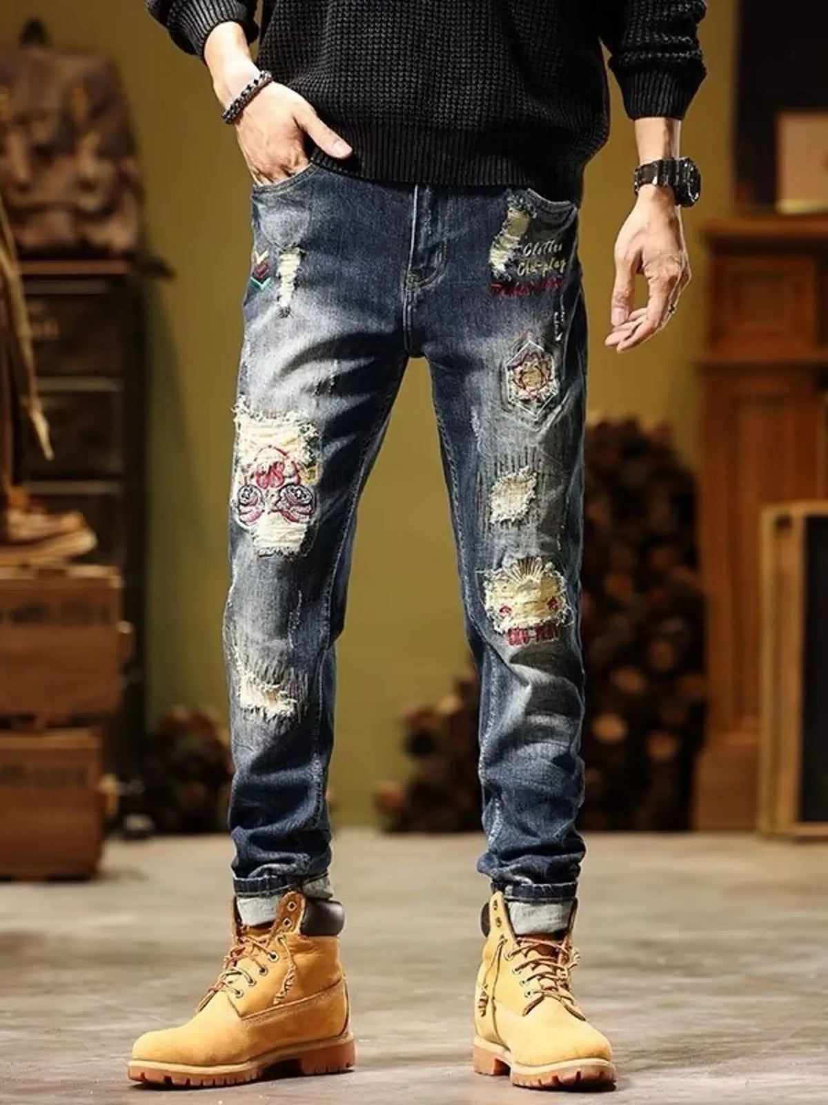 Men's blue slim-fit distressed jeans with printed patches along thighs and knees