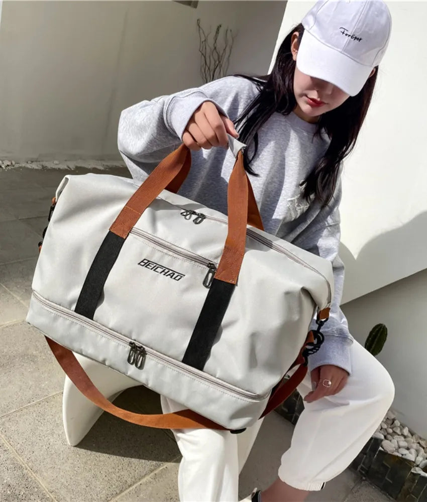 Oversize travel duffle bag in light gray with brown handles and black side stripe