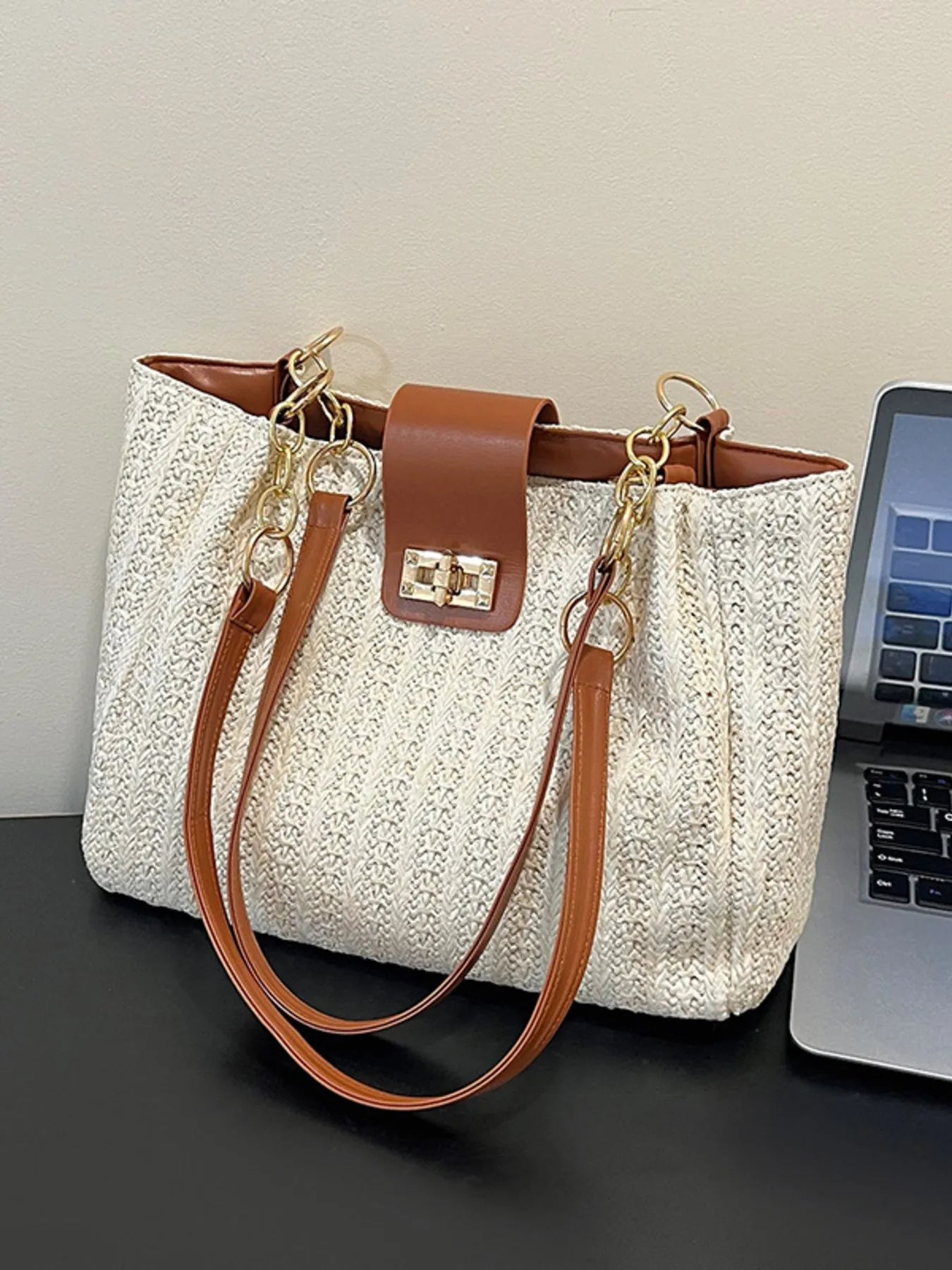 Woven straw shoulder bag with brown leather straps and gold-tone chain, beige texture