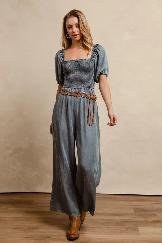 Washed denim jumpsuit with square neck smocked bodice, puff sleeves, drawstring waist