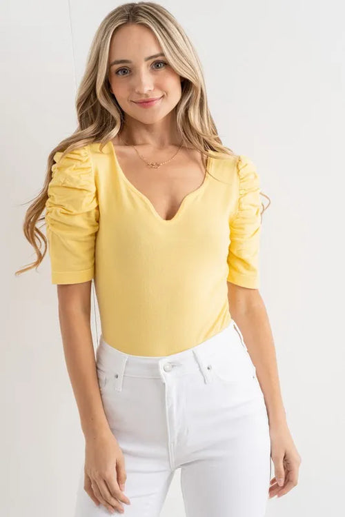 Pale yellow puff-sleeve bodysuit with shirred sleeve detailing and V-neck