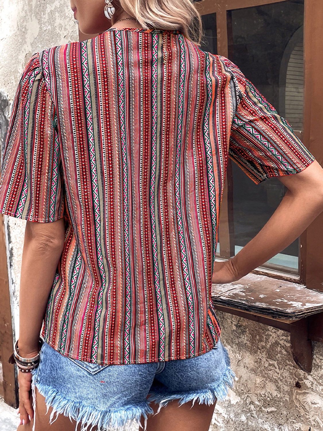 Shiny printed v-neck short sleeve button-up top, back view, red and teal stripes